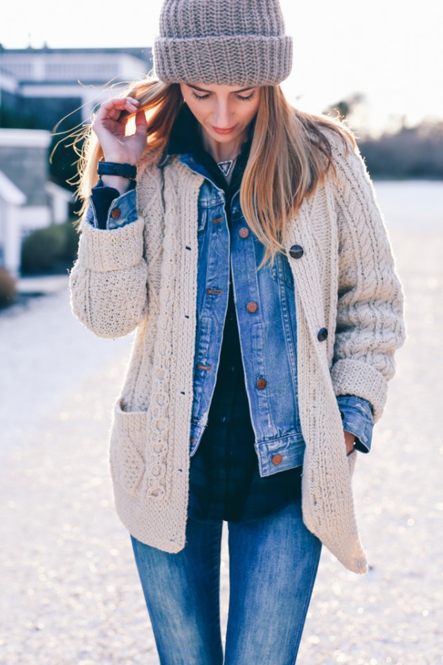 Jess Ann Kirby demonstrates this, pairing a classic Irish knit cardigan with double denim and a plaid button down.
