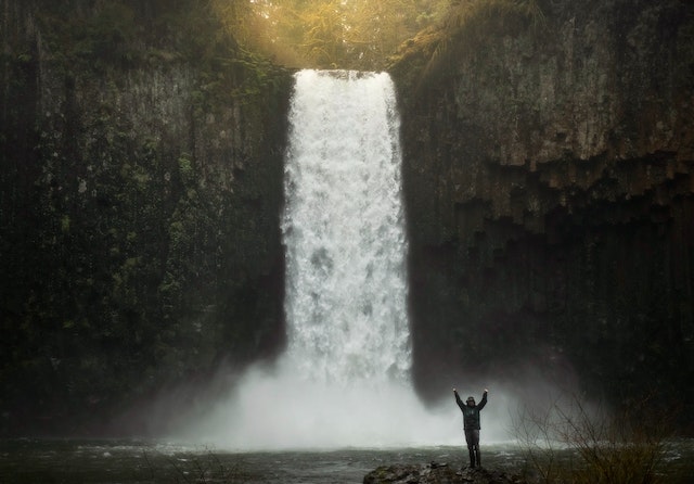 A person standing in front of a waterfall
